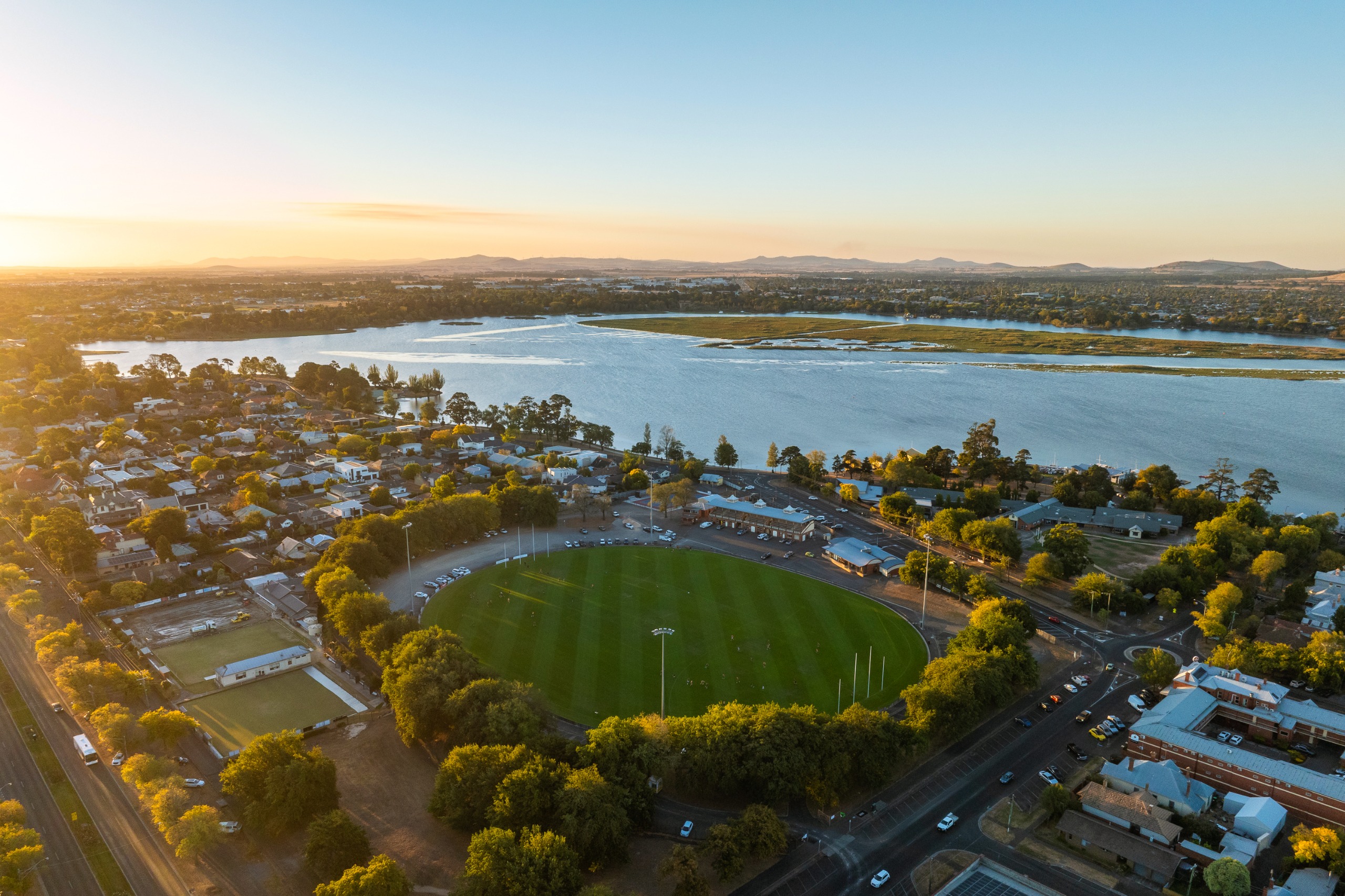 Aerial view of City Oval in Ballarat, showing the oval surrounded by trees, nearby houses and Lake Wendouree.