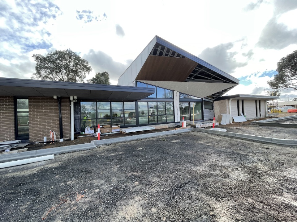 Exterior view of the newly build Vickers Street Community Hub in Sebastopol, showing a modern building with large glass windows, angled rooflines, and surrounding construction works.