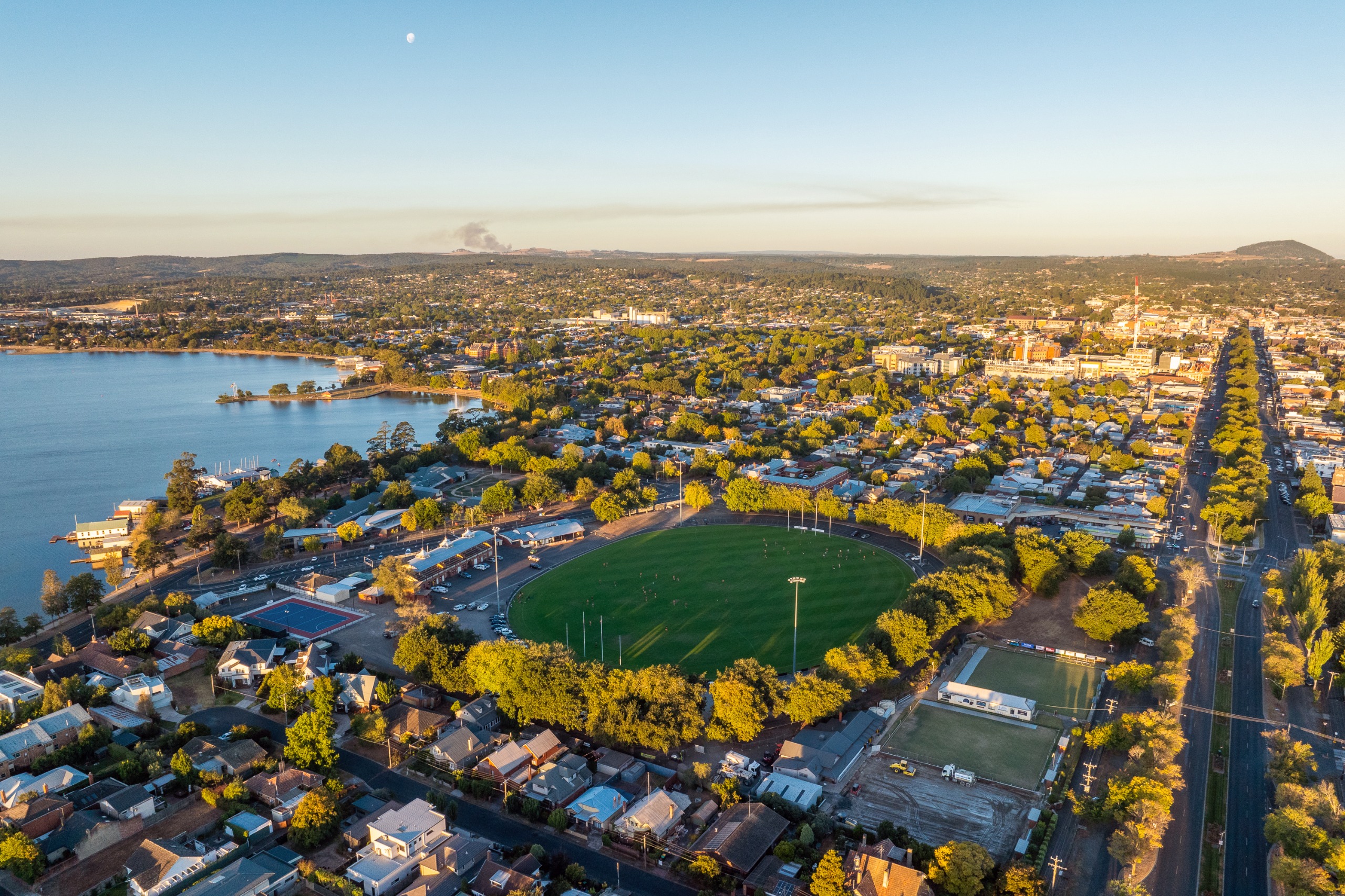 Aerial view of City Oval in Ballarat, showing the oval surrounded by trees, nearby houses and Lake Wendouree.