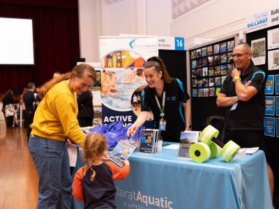 Community members speaking with City of Ballarat staff at the Ballarat Aquatic and Lifestyle Centre stall during the Let’s Chat Ballarat 2026 Community Expo at Ballarat Civic Hall.