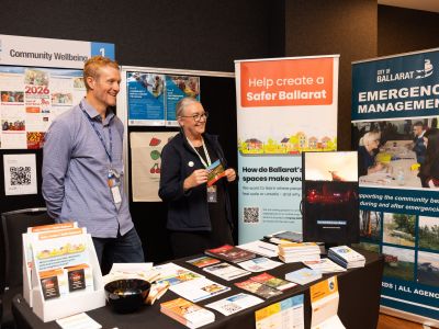 Community members speaking with City of Ballarat staff at the Community Wellbeing stall during the Let’s Chat Ballarat 2026 Community Expo. Eureka Centre Stall Display at the Eureka Centre Ballarat stall featuring flags, promotional materials and exhibits at the Let’s Chat Ballarat 2026 Community Expo.